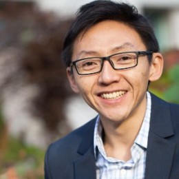 Image of Ngai Yin Yip with glasses, a light blue shirt, and a navy blazer