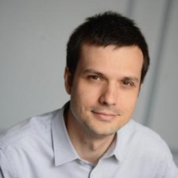 dark-haired male professor in white collared shirt